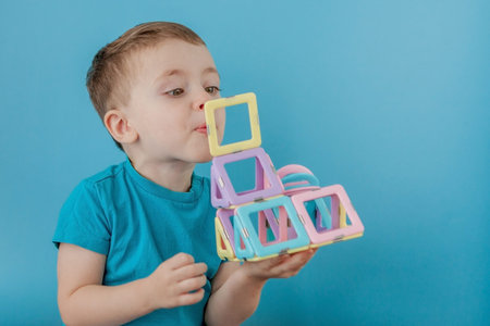 Boy looks through the shape in the color constructor with the connection of the magnets.