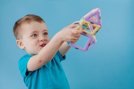 Boy looks through the shape in the color constructor with the connection of the magnets.の写真素材