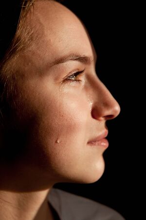 Face of young woman with tear drop close up.の写真素材