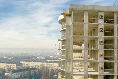 Aerial view of concrete frame of tall apartment building under construction in a city.の写真素材