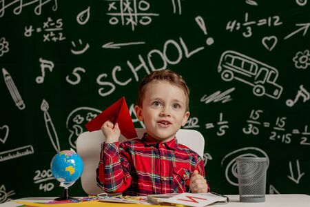 Home or school education. Pupil with paper airplane. Portrait child from elementary schoolの写真素材