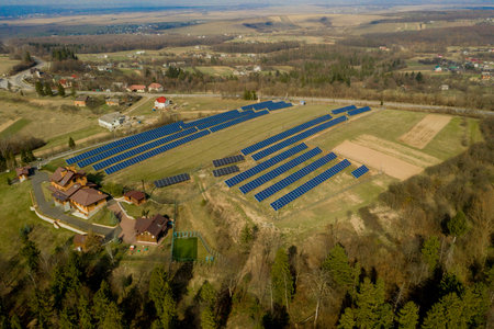 Aerial view of blue solar photo voltaic panels system producing renewable clean energy on rural...