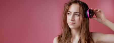 Young beautiful girl having problems while hair on pink background.の写真素材