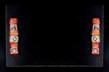 Philadelphia roll with salmon, cheese and cucumber on a black background. Sushi Philadelphia.