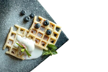 Fresh baked homemade classic Belgian waffles topped with icecream, fresh blueberries and mint isolated on white background, top down view. Savory waffles. Breakfast concept.の写真素材