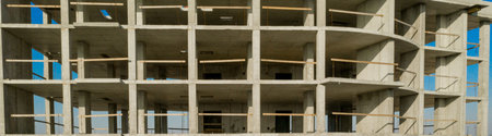 Aerial view of concrete frame of tall apartment building under construction in a city.