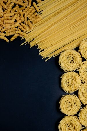 Assortment of different types of pasta dry on black backgroundの写真素材