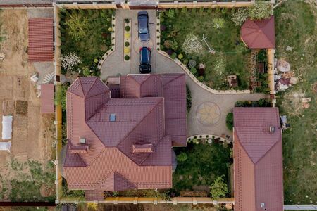 Aerial top view of a private house with paved yard with green grass lawn with concrete foundation floor.の写真素材
