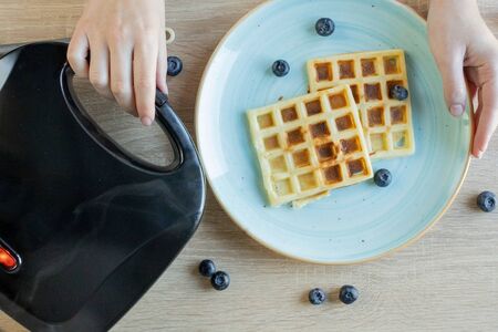 Waffles Being Baked in the Waffle Maker. Savory waffles. Breakfast concept.の写真素材