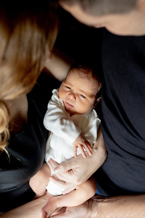 Young father and mother holding their newborn baby son. Mom, dad and baby. Happy family concept....