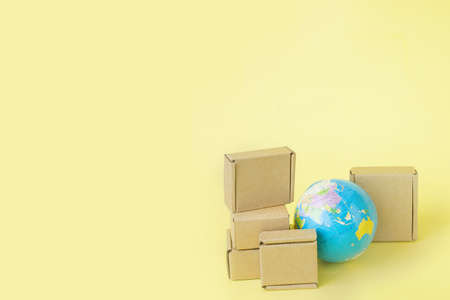 Earth globe is surrounded by boxes. Global business and international transportation of goods products. Shipping freight, world trade and economics. Distribution, import export. Commodity turnover.の写真素材