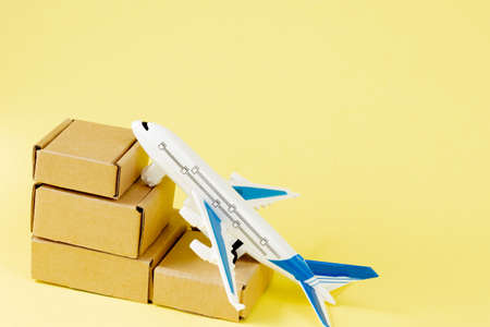 Airplane and stack of cardboard boxes. concept of air cargo and parcels, airmail. Fast delivery of goods and products. Cargo aircraft. Logistics, connection to hard-to-reach places. Banner, copy space.の写真素材