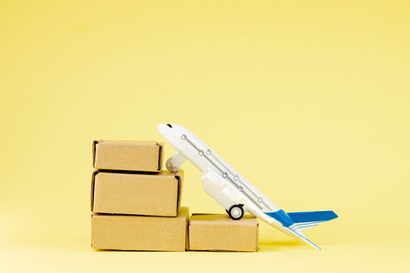 Airplane and stack of cardboard boxes. concept of air cargo and parcels, airmail. Fast delivery of...