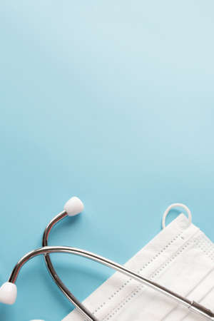 Composition with medical stethoscope, disposable face masks on a blue background. Top view. Free copy spaceの写真素材