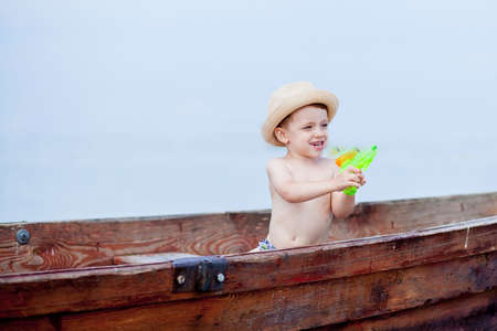 Little boy is resting in a boat on the lake.の写真素材