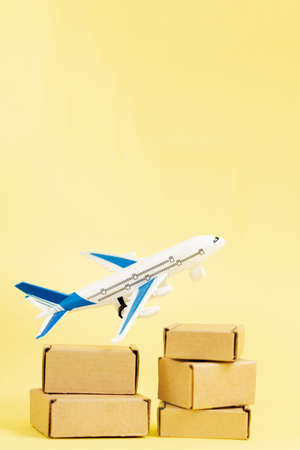 Airplane and stack of cardboard boxes. concept of air cargo and parcels, airmail. Fast delivery of goods and products. Cargo aircraft. Logistics, connection to hard-to-reach places. Bannerの写真素材