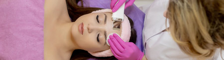 Ultrasonic scrabbing. Young woman receiving ultrasound cavitation facial peeling cleansing....