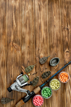 Accessories for carp fishing and fishing baits on wooden planks with copy space.