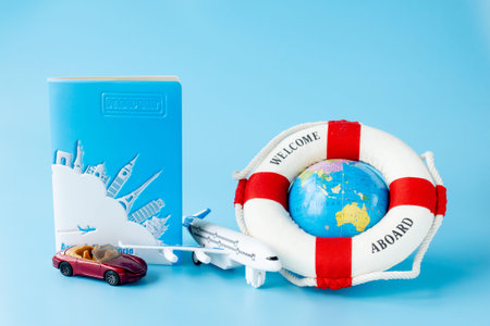 Lifebuoy, globe, model of airplane and car on blue background. Summer or vacation concept. Copy...