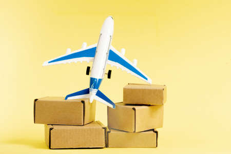Airplane and stack of cardboard boxes. concept of air cargo and parcels, airmail. Fast delivery of goods and products. Cargo aircraft. Logistics, connection to hard-to-reach places. Banner, copy space.の写真素材