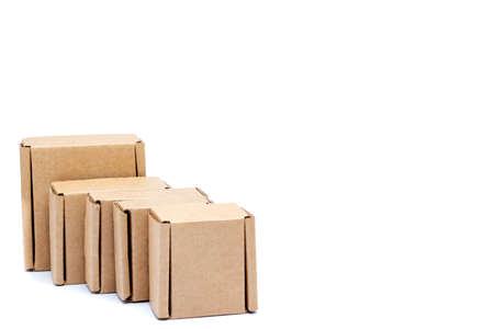 Cardboard boxes of various sizes are arranged in a row diagonally. Isolated on a white backgroundの写真素材