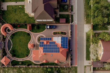 Aerial top view of new modern residential house cottage with blue panels. Renewable ecological green...