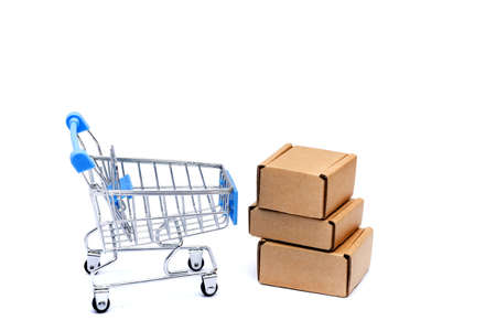 Shopping cart full of cardboard boxes, isolated on white background.の写真素材