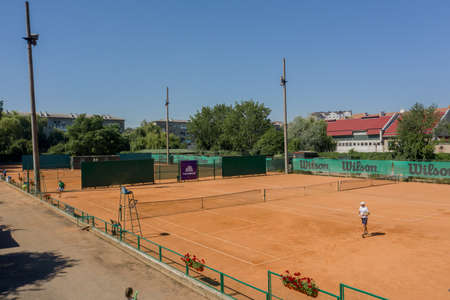 Ukraine, Kyiv- April 4, 2020: Tennis clay court seen from above with two men playing match. They are mature adult, and very agile and healthy. Video made with drone.のeditorial素材