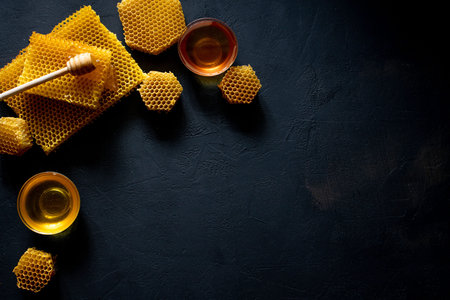 Honey with honeycomb on black table, top view. space for text.の写真素材