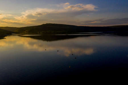 aerial view of fisherman at the boat on golden sunset river. silhouette of fishermen with his boat, Fisherman life style.の写真素材
