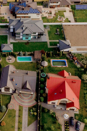 Aerial top view of a house with paved yard with green grass lawn with concrete foundation floor.