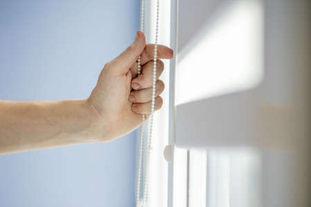Man testing cassette roller blinds on windowsの写真素材
