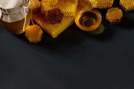 Honey with honeycomb on black table, top view. space for text.の写真素材