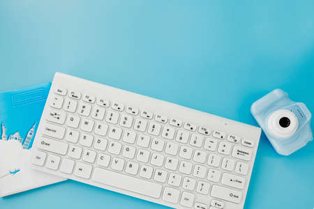 Booking and search flight ticket air international travel concept, keyboard, passport and camera on blue background. Summer or vacation concept. Copy space.の写真素材
