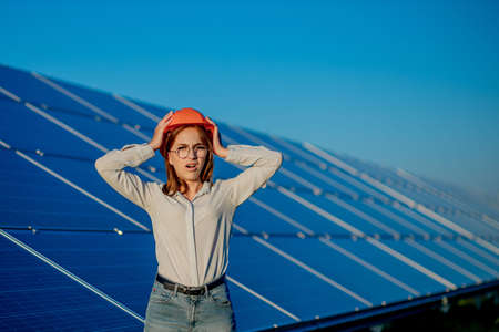 Beautiful young engineer standing near solar panels outdoors, Green Energy Concept.の写真素材