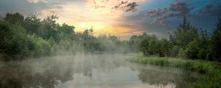 Sunrise with mist over a lake at the wetlands.の写真素材