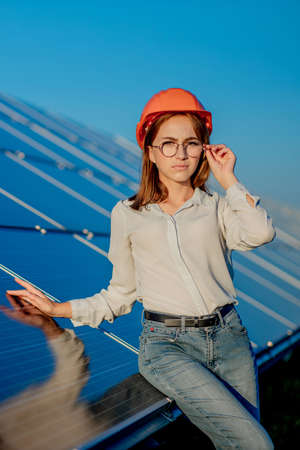 Beautiful young engineer standing near solar panels outdoors, Green Energy Concept.の写真素材