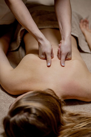 Masseur doing massage on man body in the spa salon. Beauty treatment conceptの写真素材