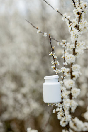 Allergy pills against the blooming plants background.の写真素材