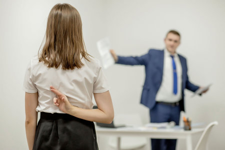 Angry boss yelling at his young employee, she is stressed and feeling frustrated: hostile boss and mobbing concept.の写真素材