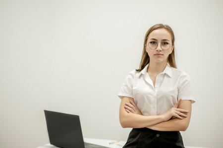 Close-up portrait of a young confident female office manager at her workplace, ready for doing business taskの写真素材