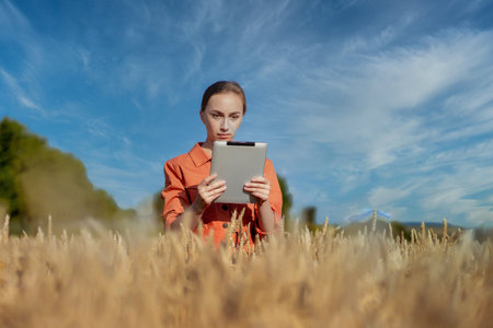 Caucasian Agronomist checking the field of cereals and sends data to the cloud from the tablet....