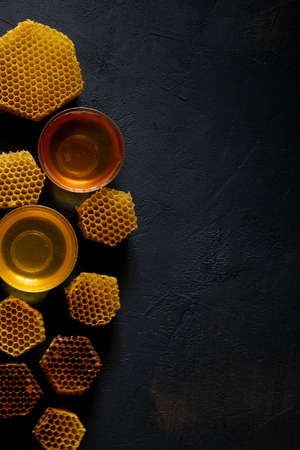 Honey with honeycomb on black table, top view. space for text.の写真素材