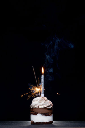 Chocolate and Raspberry Birthday Cake with Sparkler on Dark Background.