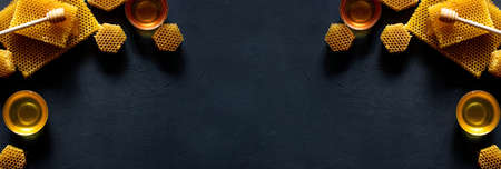 Honey with honeycomb on black table, top view. space for text.の写真素材