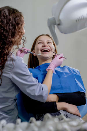 Professional doctor dentist examine and treat spoiled teeth with the use of special dental instruments, medical equipments. Healthy teeth conceptの写真素材