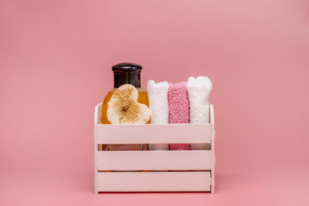 Flat lay composition with spa cosmetics and towel on pink background.の写真素材