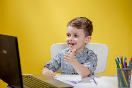 Distance learning online education. A schoolboy boy studies at home and does school homework. A home...