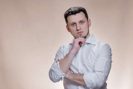 portrait of stylish caucasian male on brown background. handsome young guy is looking at camera.の写真素材