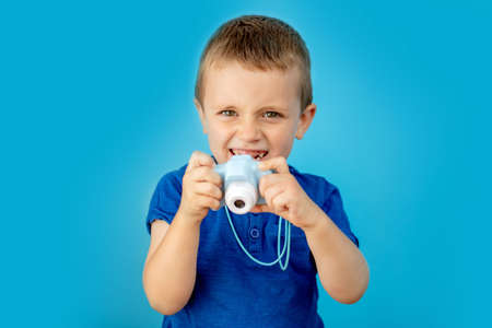 Little photographer with toy camera on blue background.の写真素材